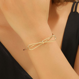 Золотистый браслет-кафф с центральным элементом в виде банта 1J12459CJJ